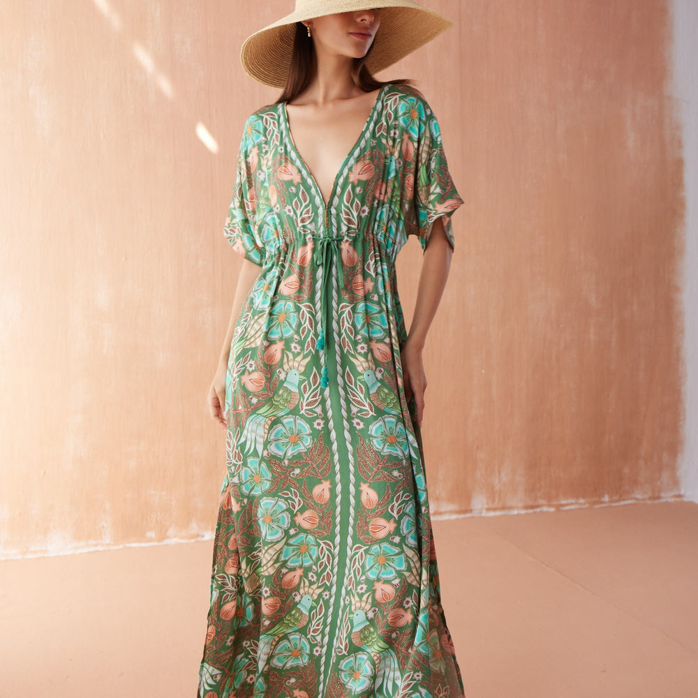 Front view of model wearing Pia Caftan in Kala Kelp, featuring deep V-neckline, flowing silhouette, and tropical floral print.