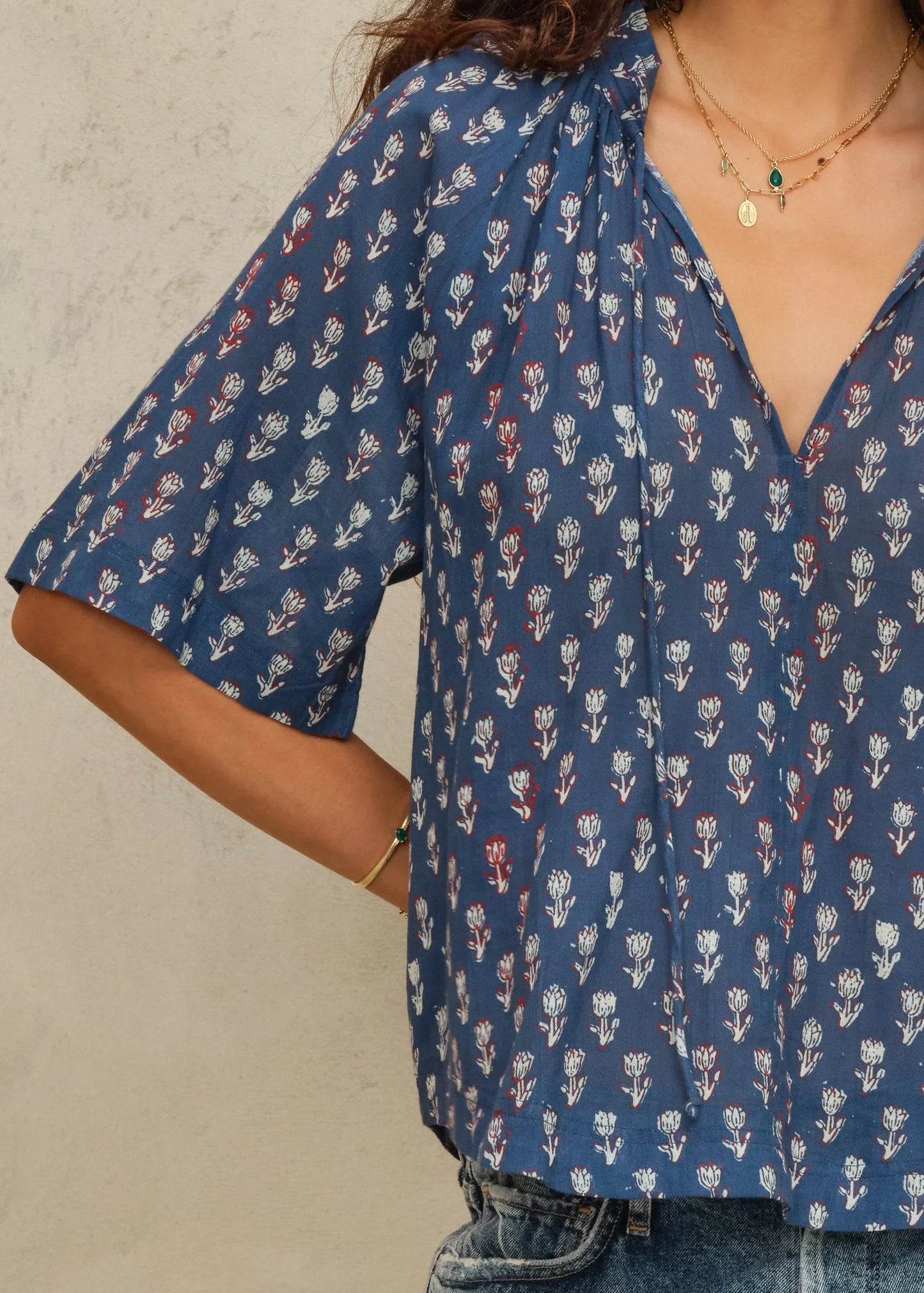 Person wearing a blue floral patterned shirt against a neutral background