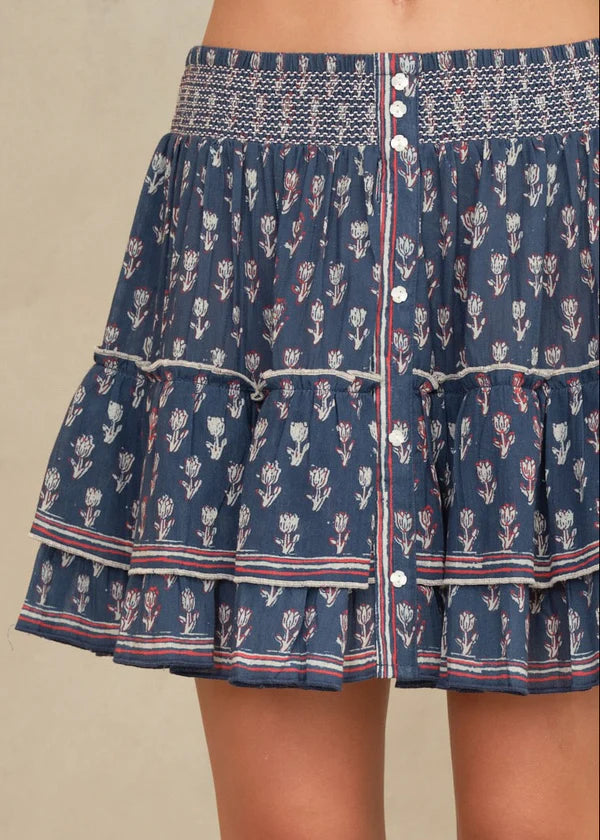 Navy blue patterned skirt with white buttons on a beige background