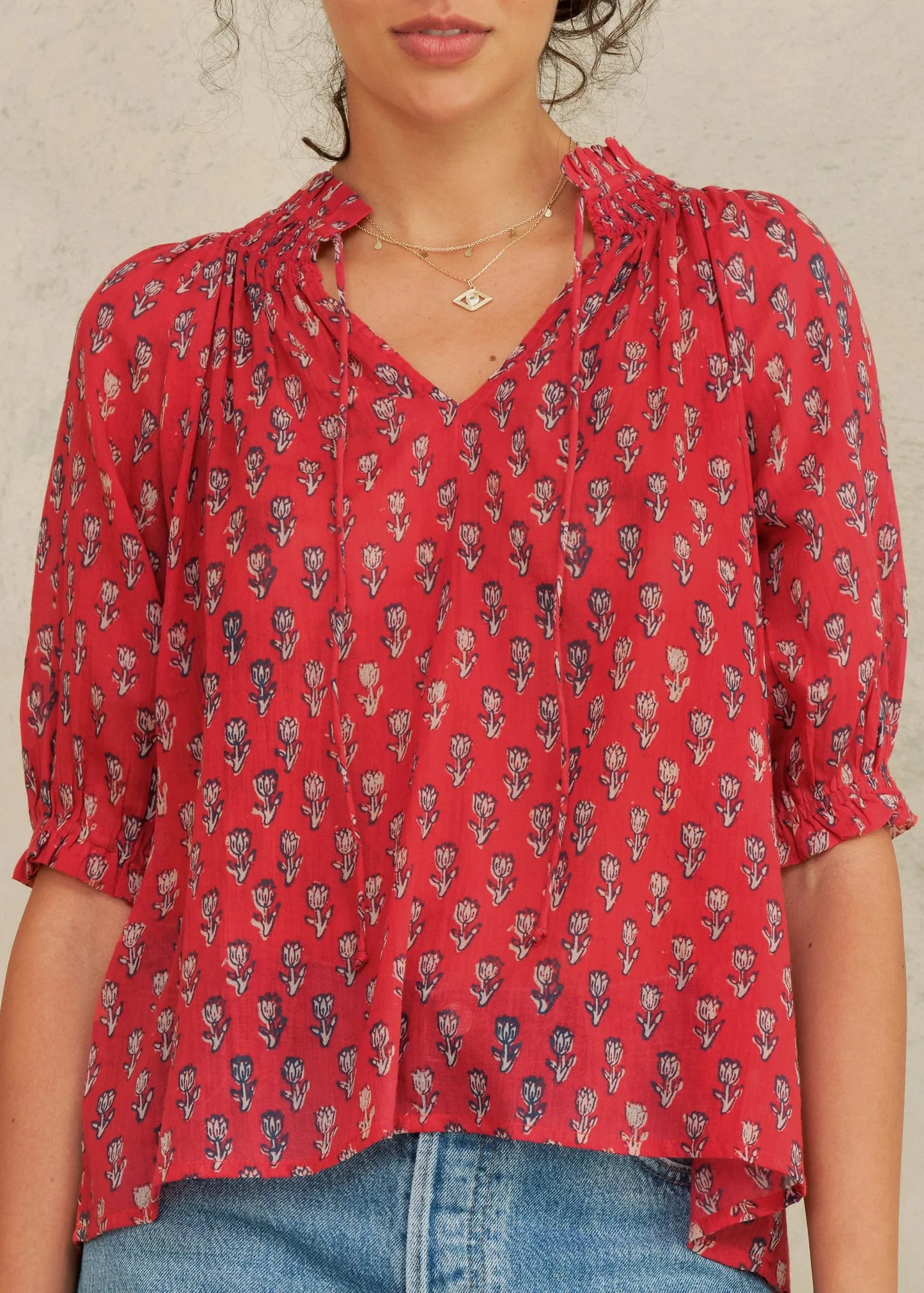 Red floral blouse worn by a person on a neutral background