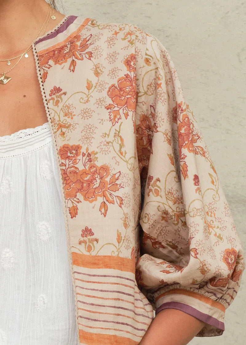 Floral patterned kimono over a white top against a neutral background