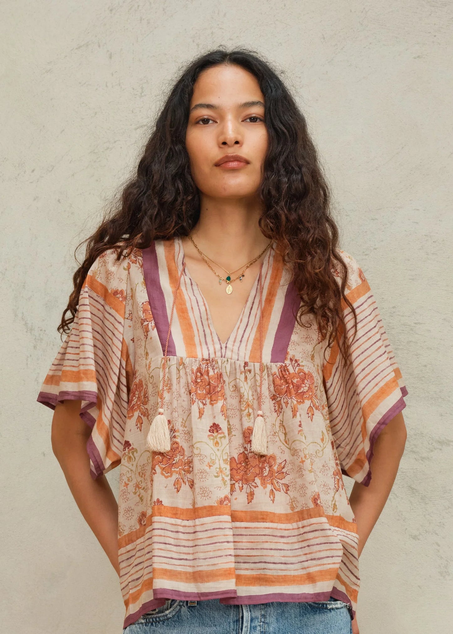 Woman wearing a patterned blouse against a plain background
