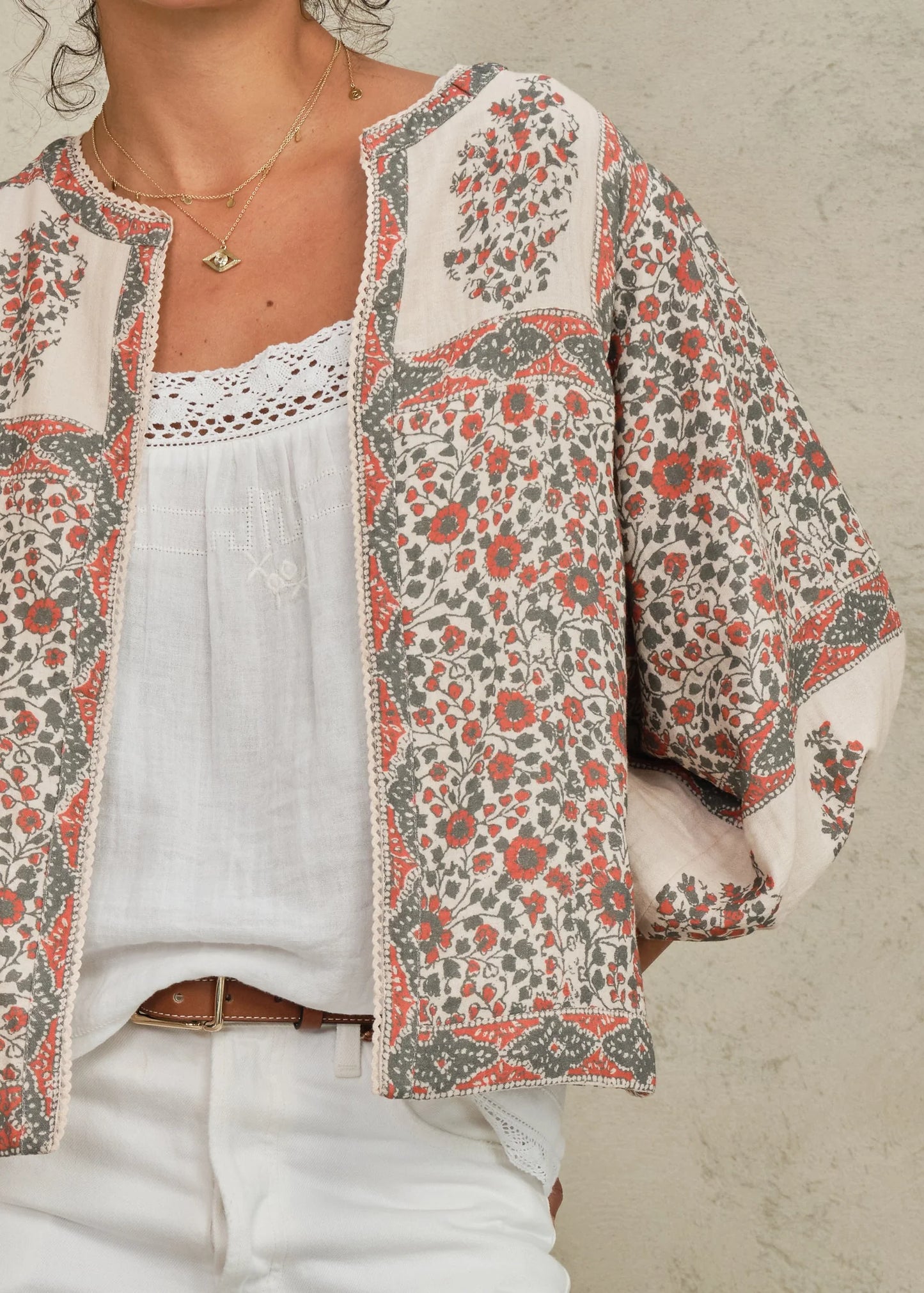Floral patterned jacket over a white top on a neutral background