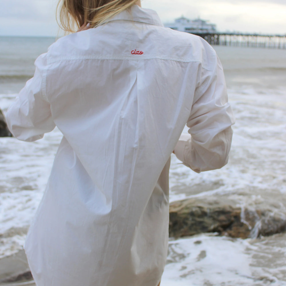 Made in a crisp white cotton fabric, the Ciao Shirt Dress is the perfect oversized, classic button-down with a special embroidered "Ciao" detail on the back. The carefully placed buttons on the cuff and the extra length in the back to provide more coverage prove that our signature shirt dress is a cover-up

