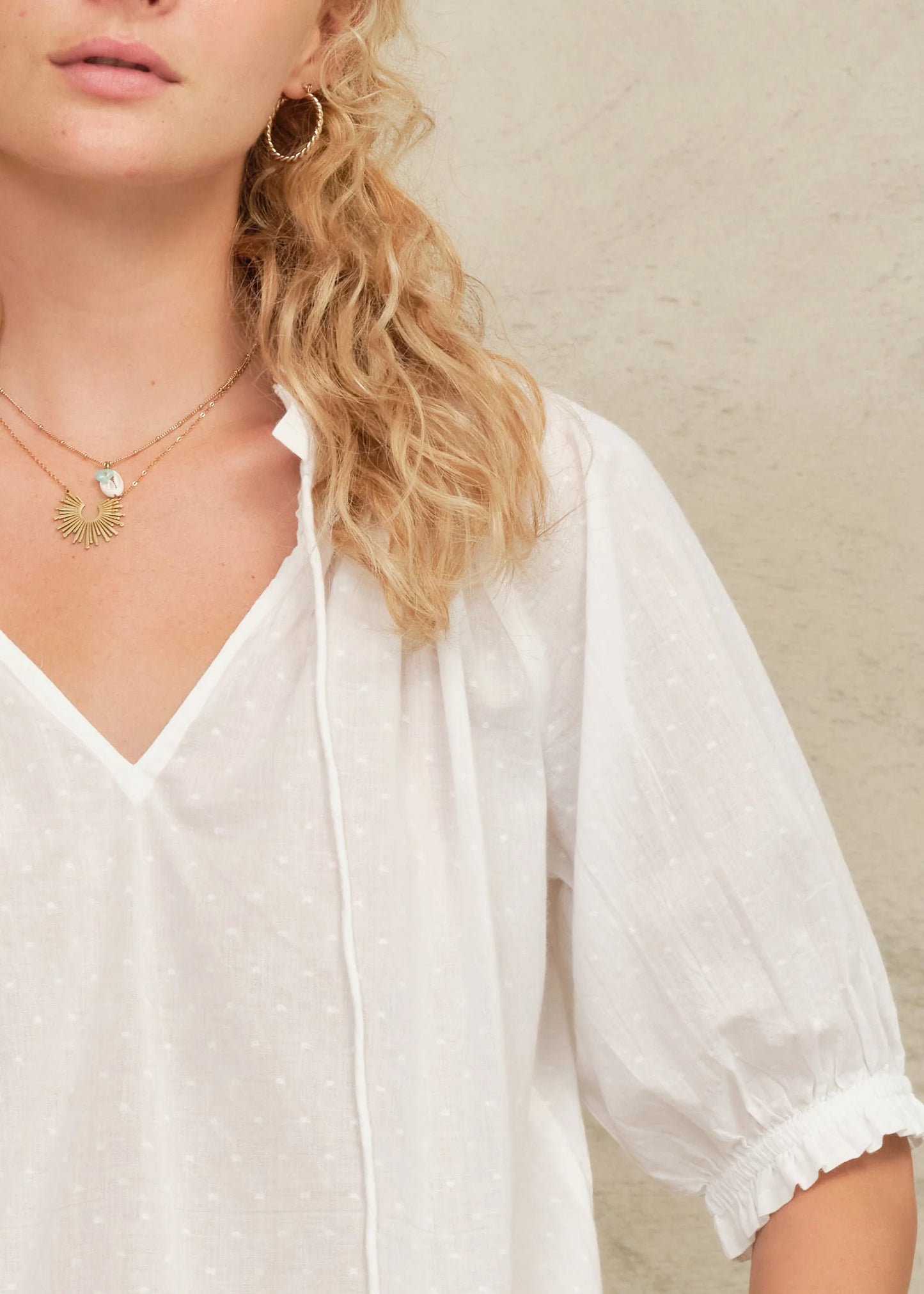 Woman wearing a white blouse with a neutral background