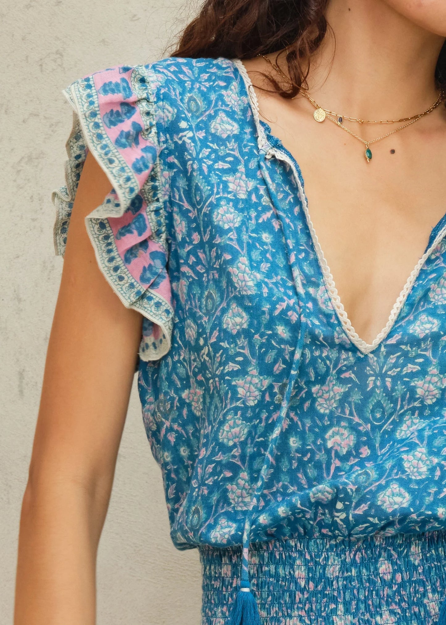 Blue floral dress with ruffled sleeves on a neutral background