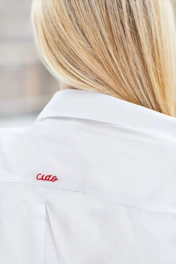 Made in a crisp white cotton fabric, the Ciao Shirt Dress is the perfect oversized, classic button-down with a special embroidered "Ciao" detail on the back. The carefully placed buttons on the cuff and the extra length in the back to provide more coverage prove that our signature shirt dress is a cover-up
